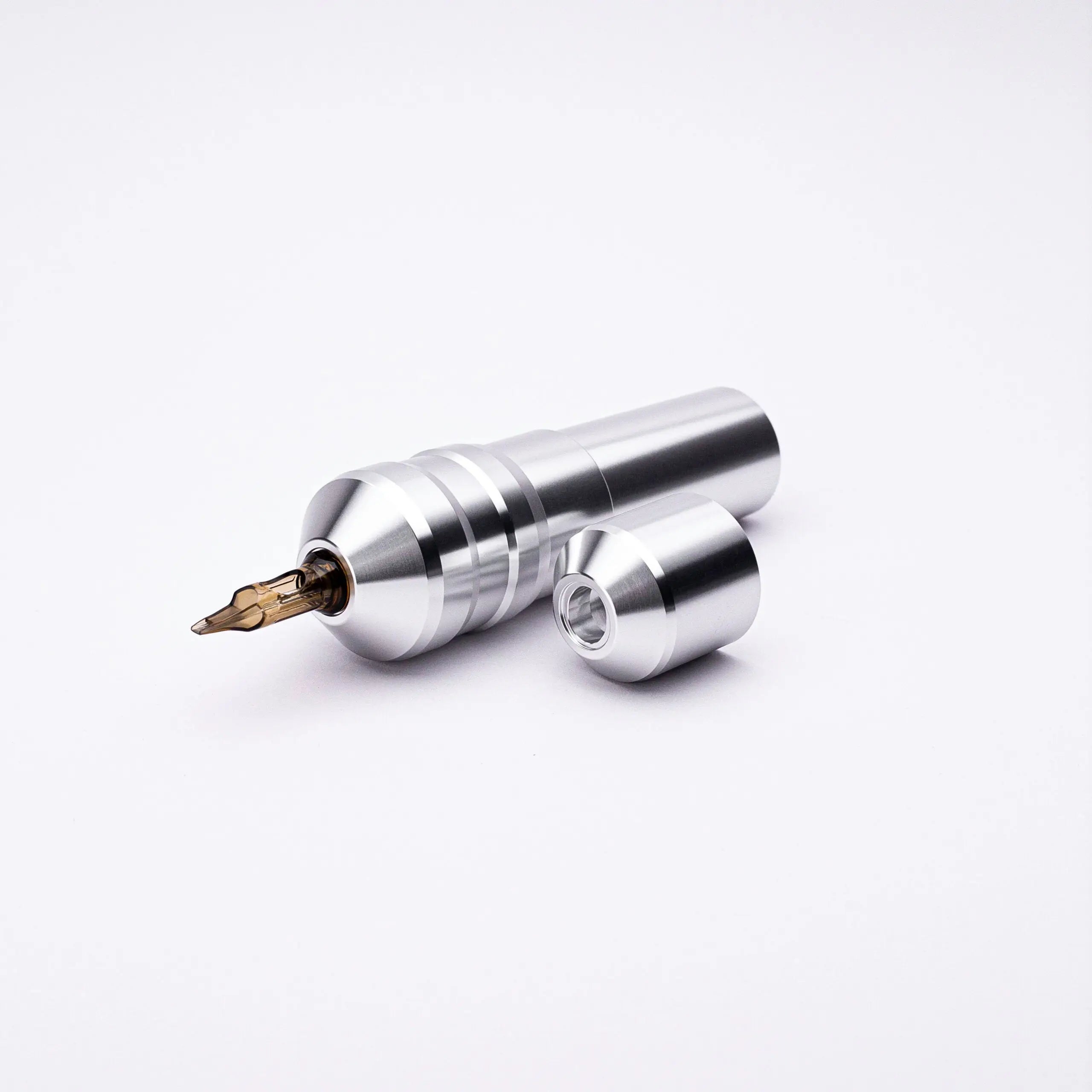 Silver metallic ACUS M1 Ayre tattoo machine with gold needle tip and matching cylindrical cap for professional use
