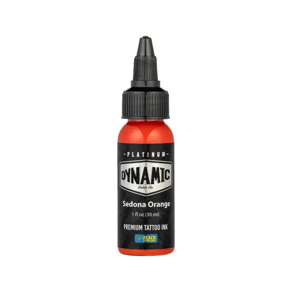 A vibrant orange liquid-filled bottle of dynamic platinum sedona orange tattoo ink with a black cap and white label