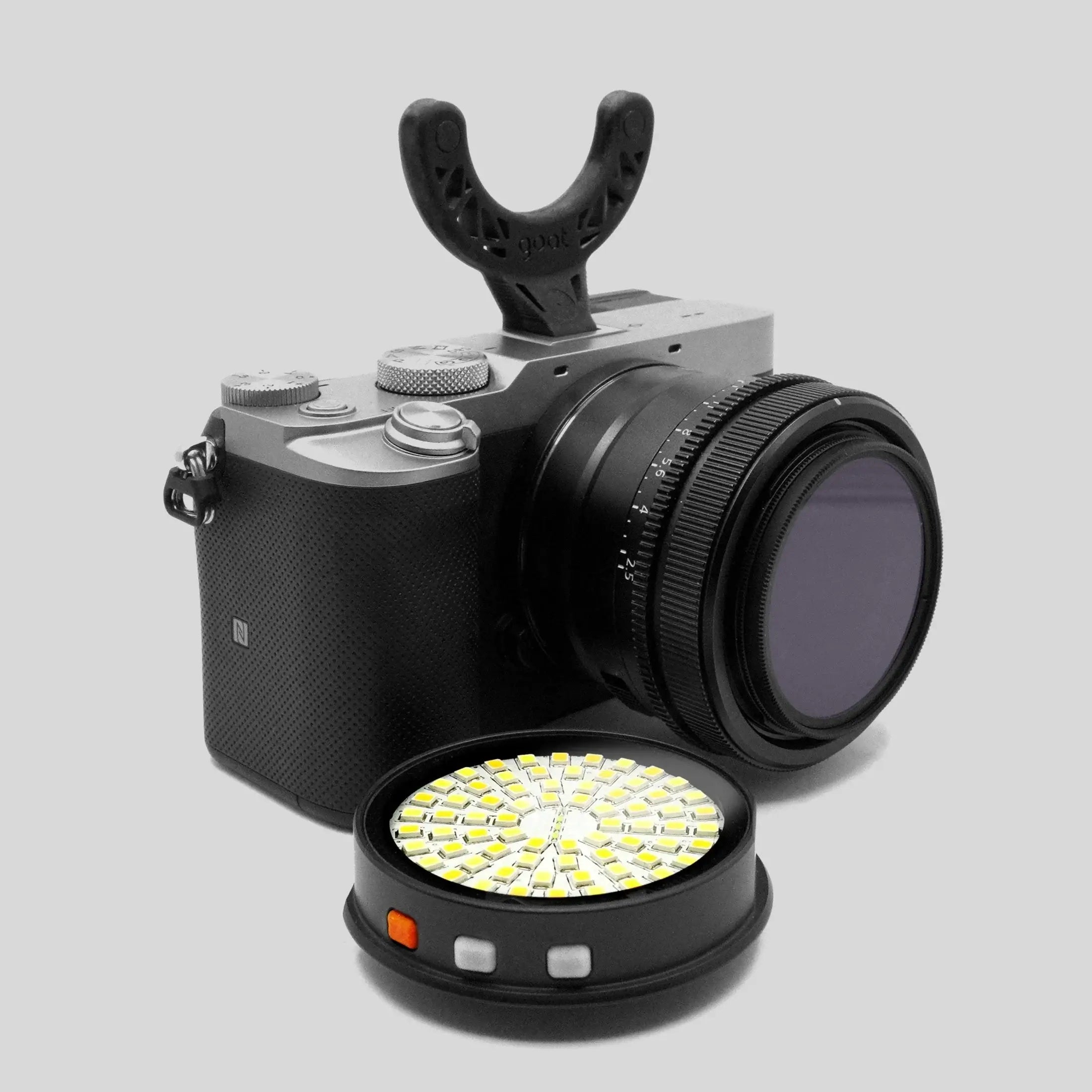 Black and silver GOAT light support camera with black lens and black u-shaped grip mount for stable shooting