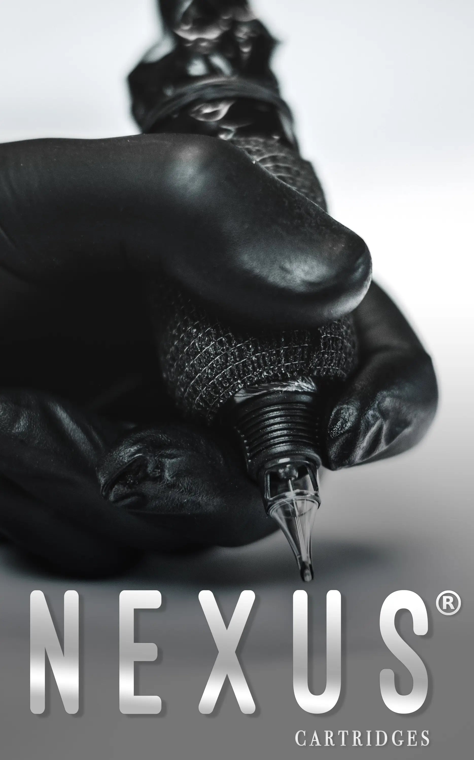 NEXUS round liner tattoo cartridge in black textured material with metallic tip held in gloved hands