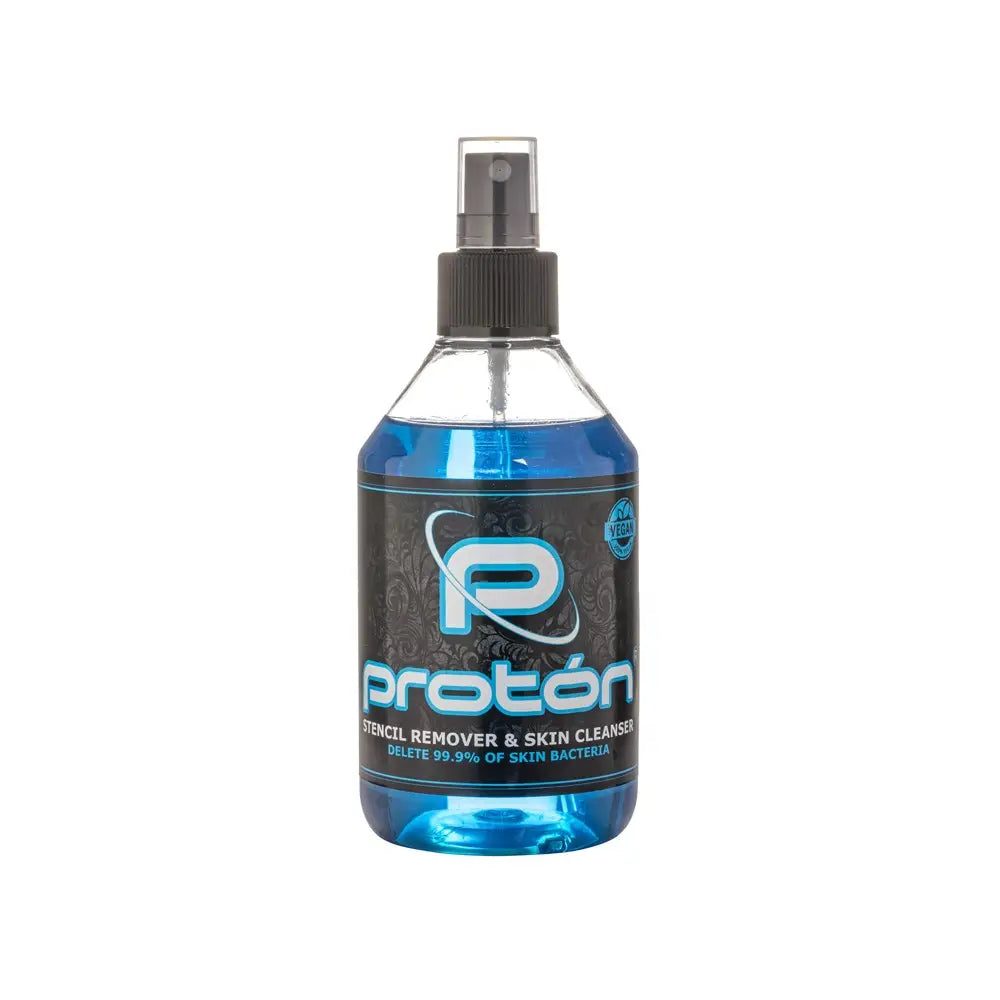 A clear plastic spray bottle with black nozzle filled with blue proton stencil remover and skin cleanser 250 ml