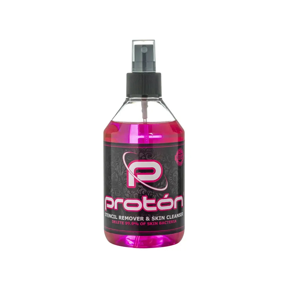 A vibrant pink liquid fills a clear plastic spray bottle with black nozzle labeled proton stencil remover and skin cleanser