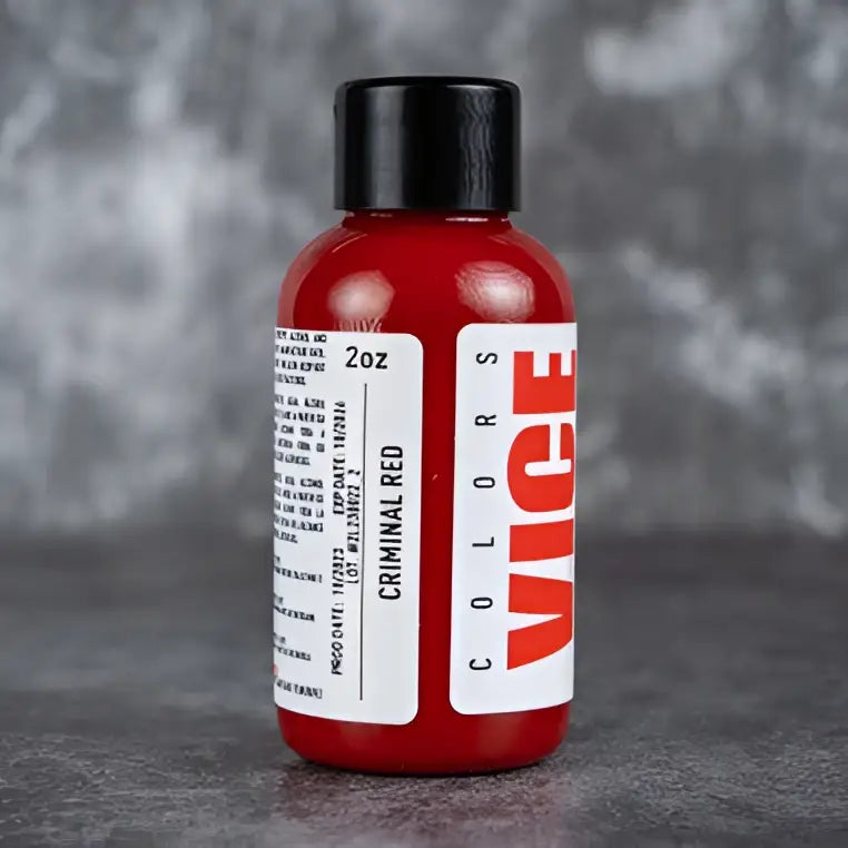 A vibrant red glossy plastic bottle with a black cap and bold vice colors label for vice criminal red product
