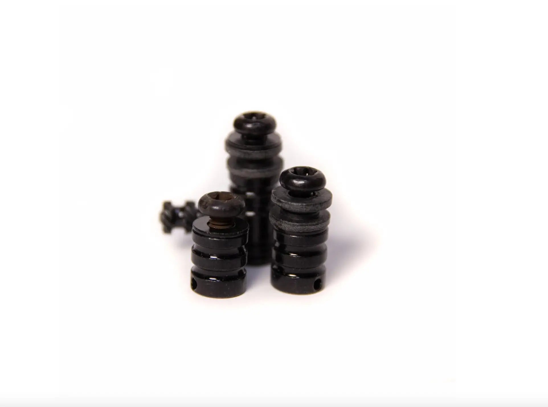 Schwarze zylindrische Kunststoff-Bindepfosten mit geriffelten Oberflächen und Gewindespitzen aus dem VLAD BLAD Bolt-On-Kit