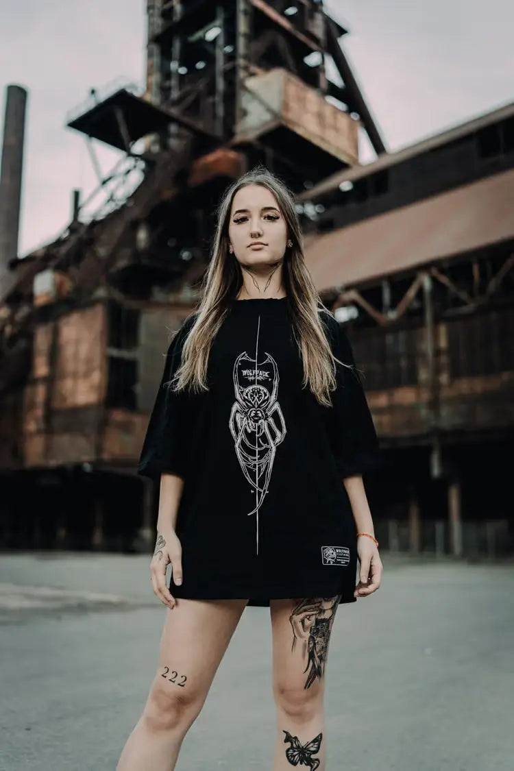 Black oversized tee unisex with white spider graphic and wildfire text from wolfpack connection collection wears size unisex