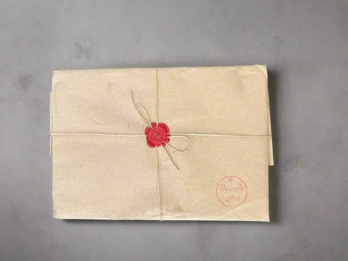 alt
Eine beigefarbene, in Papier gewickelte holzige synthetische Kunsthaut A5, 5 mm, versiegelt mit einem roten Wachssiegel und mit Bindfaden zusammengebunden