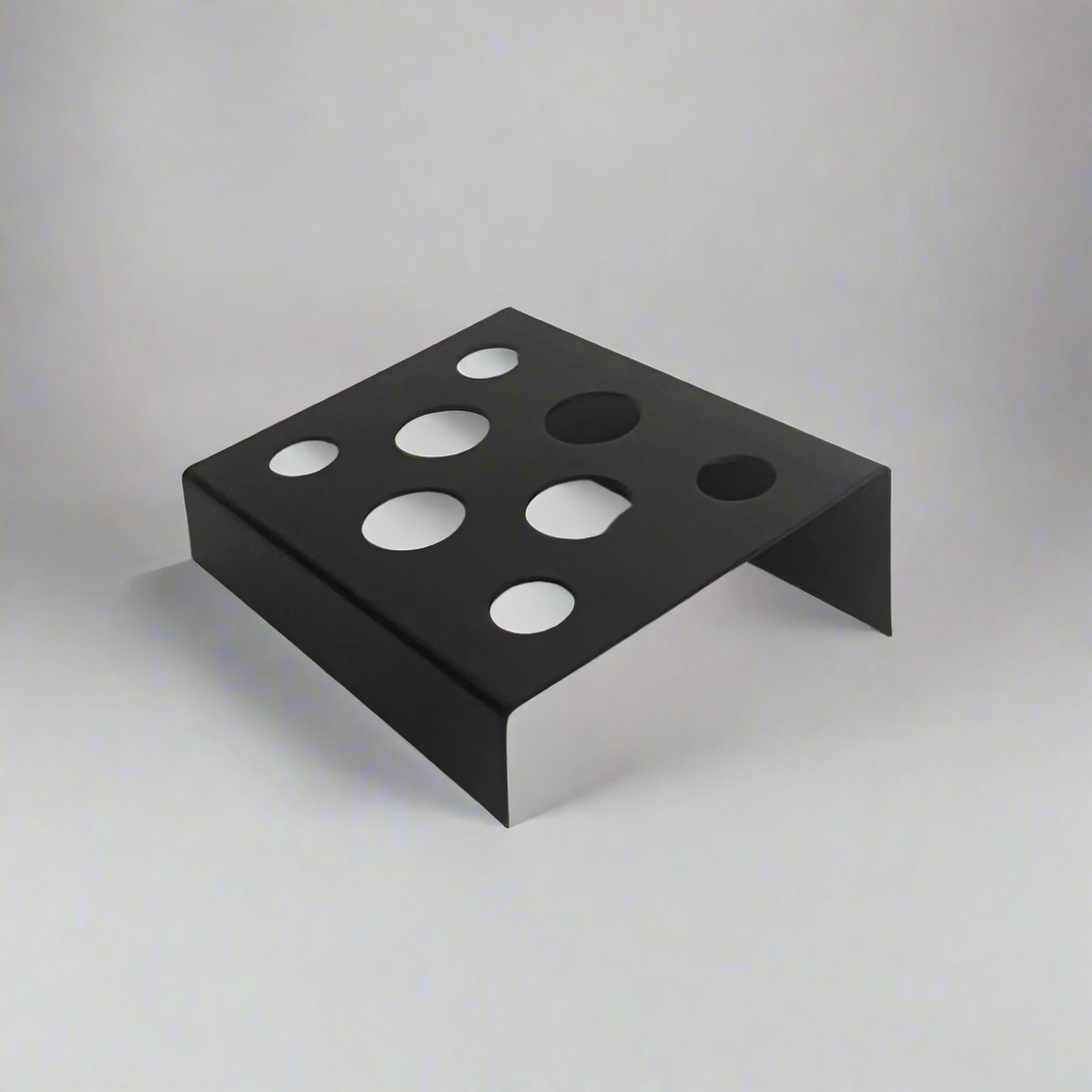 Black metal wall-mounted shelf with circular holes on a gray background