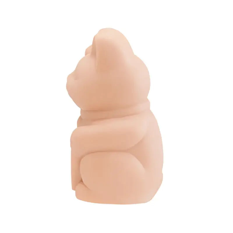 Eine weiche, pfirsichfarbene, glatte Keramikfigur eines sitzenden Bären mit abgerundeten Ohren und einem schlichten Schal von a pound of flesh lucky cat