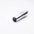 Silver cylindrical ACUS M1 Ayre tattoo machine with black control panel and gold-colored needle tip for precise tattooing