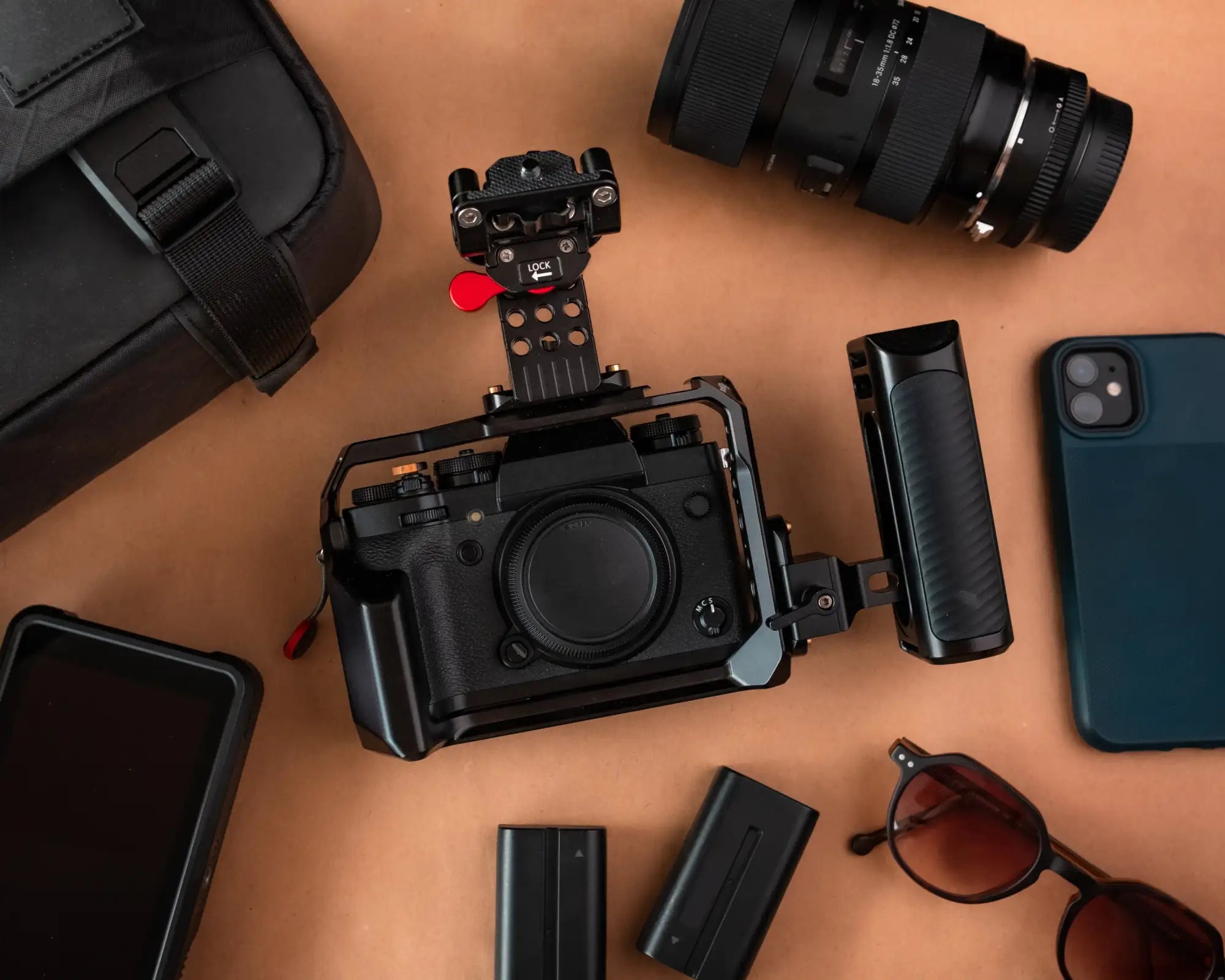 Black fujifilm camera with a rugged grip and mounted cage.