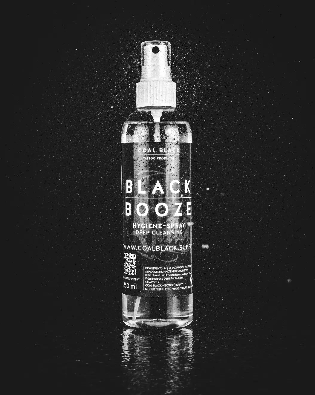 Clear glass bottle with white spray nozzle and black label reading black booze for hygienic deep cleansing spray coal black