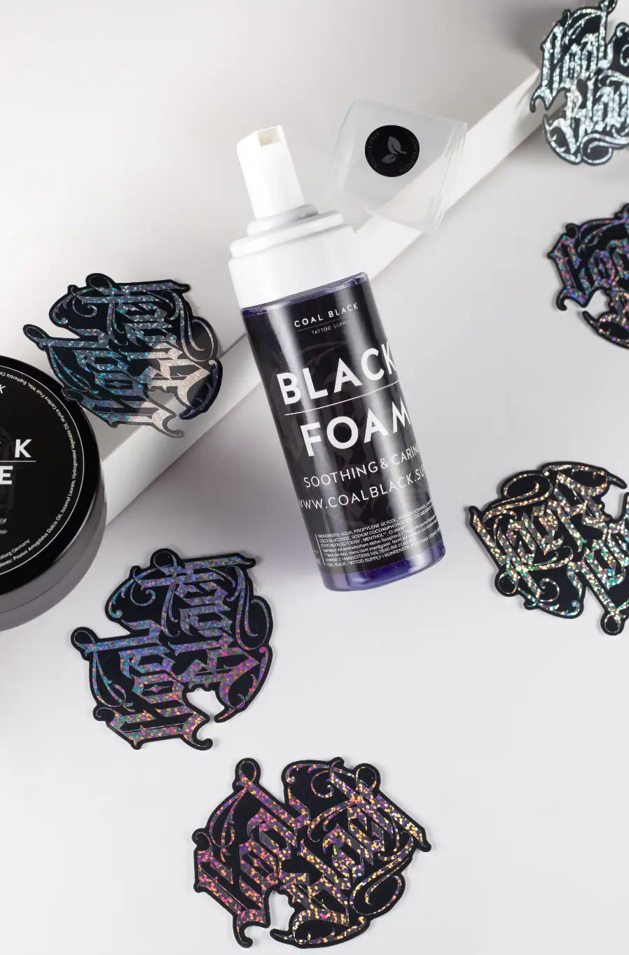 Eine elegante, durchscheinende violette Flasche mit beruhigendem und entspannendem Schaum in COAL BLACK, mit weißer Sprühdüse und schwarzem Etikett