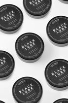 Coal black black lube in sleek black cylindrical containers with bold white branding for smooth lubrication