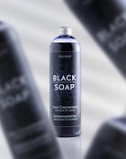 Eine elegante dunkle Glasflasche mit COAL BLACK Seifenkonzentrat, silbernem Verschluss und minimalistischem schwarzem Etikett mit weißer Schrift