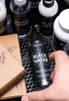 Coal black black water shading solution in a sleek transparent bottle with black cap and label