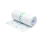 A roll of white grid-patterned adhesive protective tattoo film tape with green arrows and dermatix logo in blue