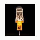 Transparent orange-tinted edge pro tattoo needle cartridge with metallic tip and fine evenly spaced prongs for magnum use