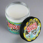 Eine weiße, cremige Vaseline in einem klaren Glasgefäß mit schwarzem Deckel und farbenfrohem good hand-Biest-Branding sowie Biest-Bildsprache