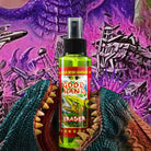 Grüne Sprühflasche good hand-Radierer mit Dinosaurier-Comicetikett, gehalten zwischen grünen und orangefarbenen strukturierten Kiefern