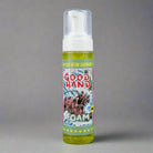 Eine leuchtend gelbe Schaum-Handdesinfektionsflasche mit weißer Pumpe und farbenfrohem Comic-Style-good hand-Schaumetikett auf grauem Hintergrund
