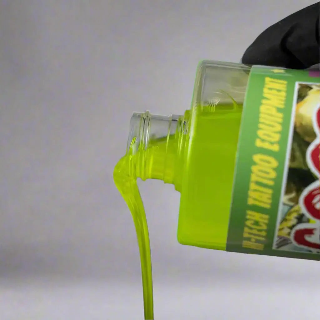 A translucent green bottle of good hand green soap concentrate with bright lime green liquid is being poured