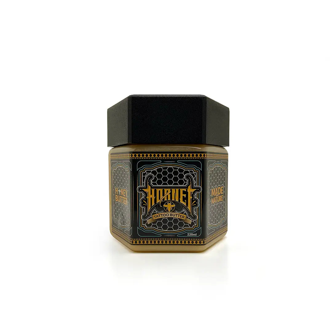 Schwarzes sechseckiges Glas mit HORNET Tattoo-Butter 220 ml, mit gold-schwarzem Etikett mit Bienenemblem