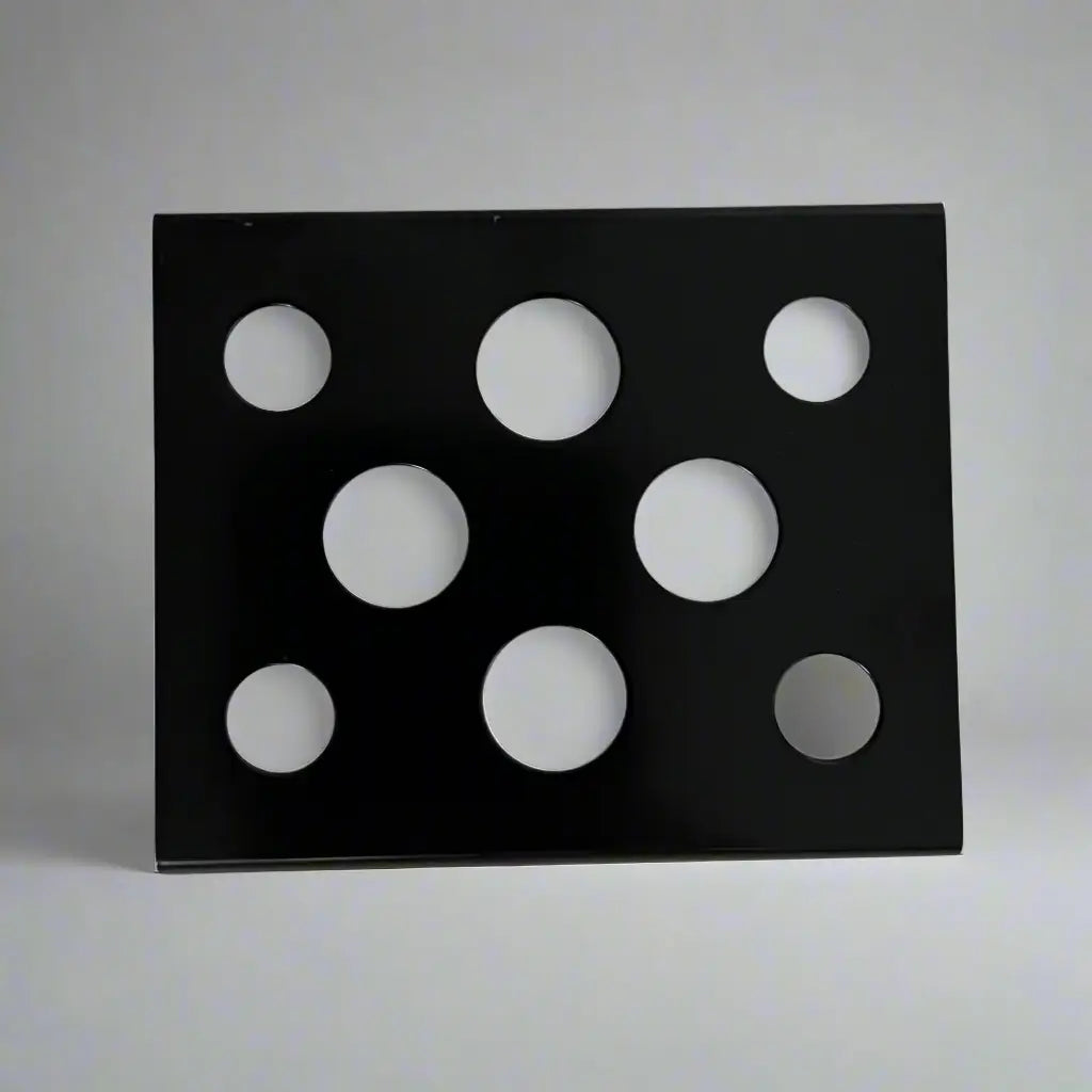 Black metal ink cup holder with seven circular cutouts in varying sizes for organized ink storage