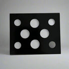 Black metal ink cup holder with seven circular cutouts in varying sizes for organized ink storage