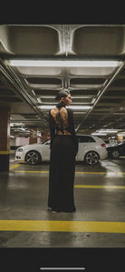 A woman wearing the back of a black kalu ibiza ibiza dj dress with long sleeves and intricate tattooed design