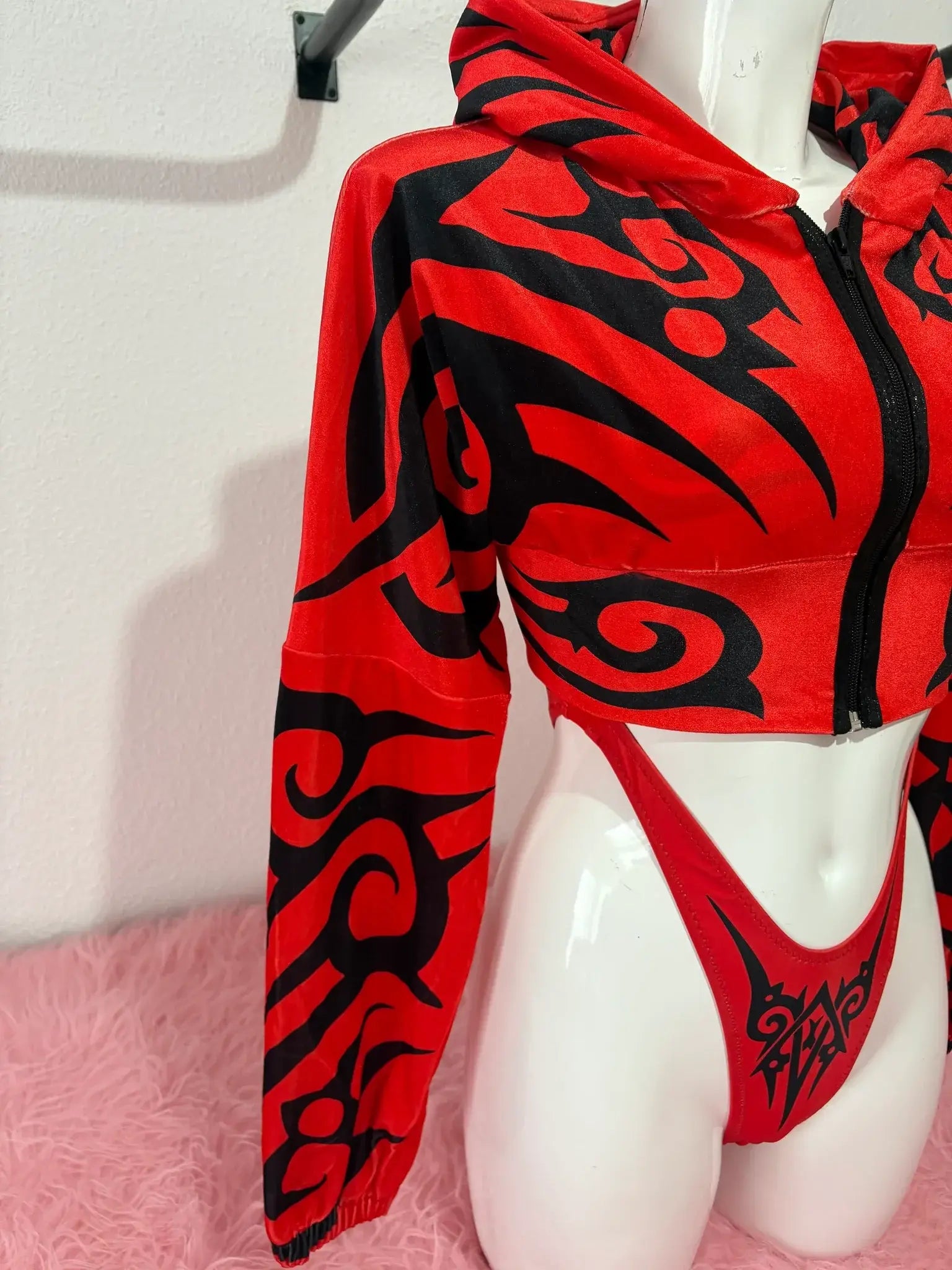 Felpa corta con motivo tribale rosso e nero e slip rossi a vita alta su manichino della collezione kalu ibiza much tribal