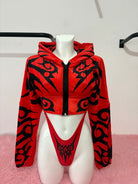alt
Felpa corta Kalu Ibiza Much con motivo tribale rosso e nero e slip abbinati a sgambatura alta su manichino