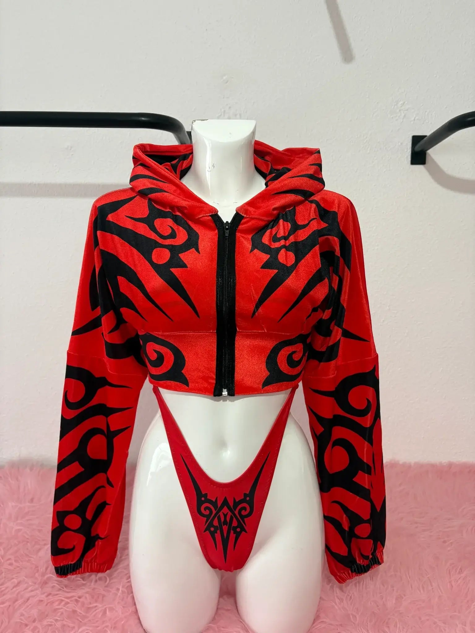 alt
Felpa corta Kalu Ibiza Much con motivo tribale rosso e nero e slip abbinati a sgambatura alta su manichino
