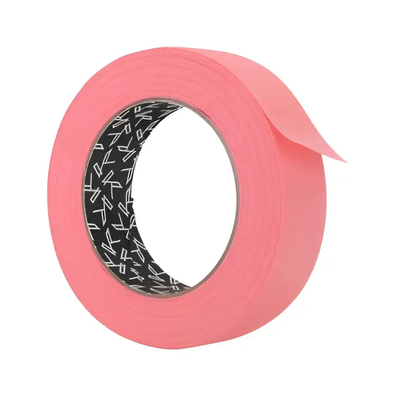 Eine Rolle leuchtend pinkes killer ink Papierklebeband mit schwarz-weiß gemustertem Innenkern für Malerarbeiten