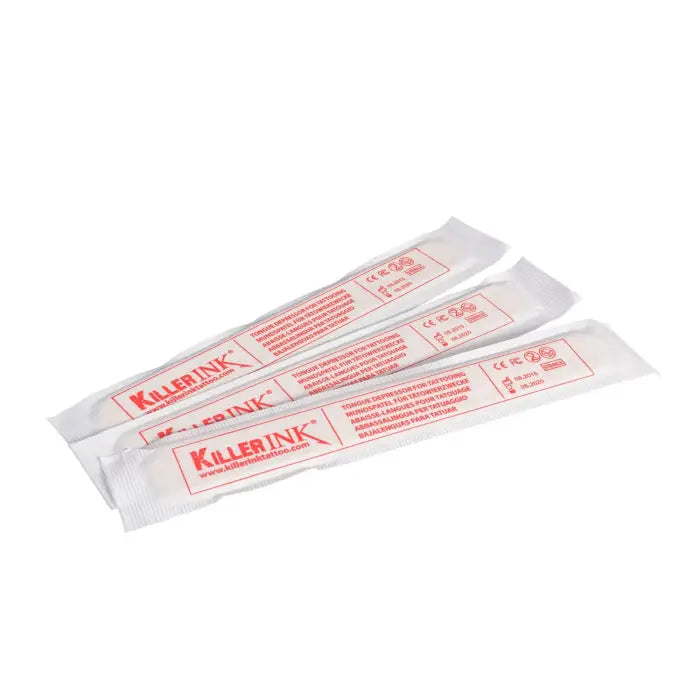 Three white individually wrapped sterile wooden tongue depressors with red killer ink branding and text