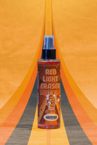 Red liquid in a clear spray bottle with black nozzle labeled red light eraser by hozelock for kosmos use