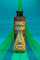 A vibrant green bottle of Kosmos space soap with a retro-style label and cartoon astronaut character design