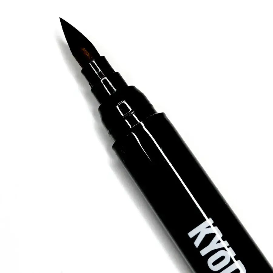 Black Kyocera Kyodai firm-tip brush pen with fine pointed tip and metallic accents for precise writing and drawing