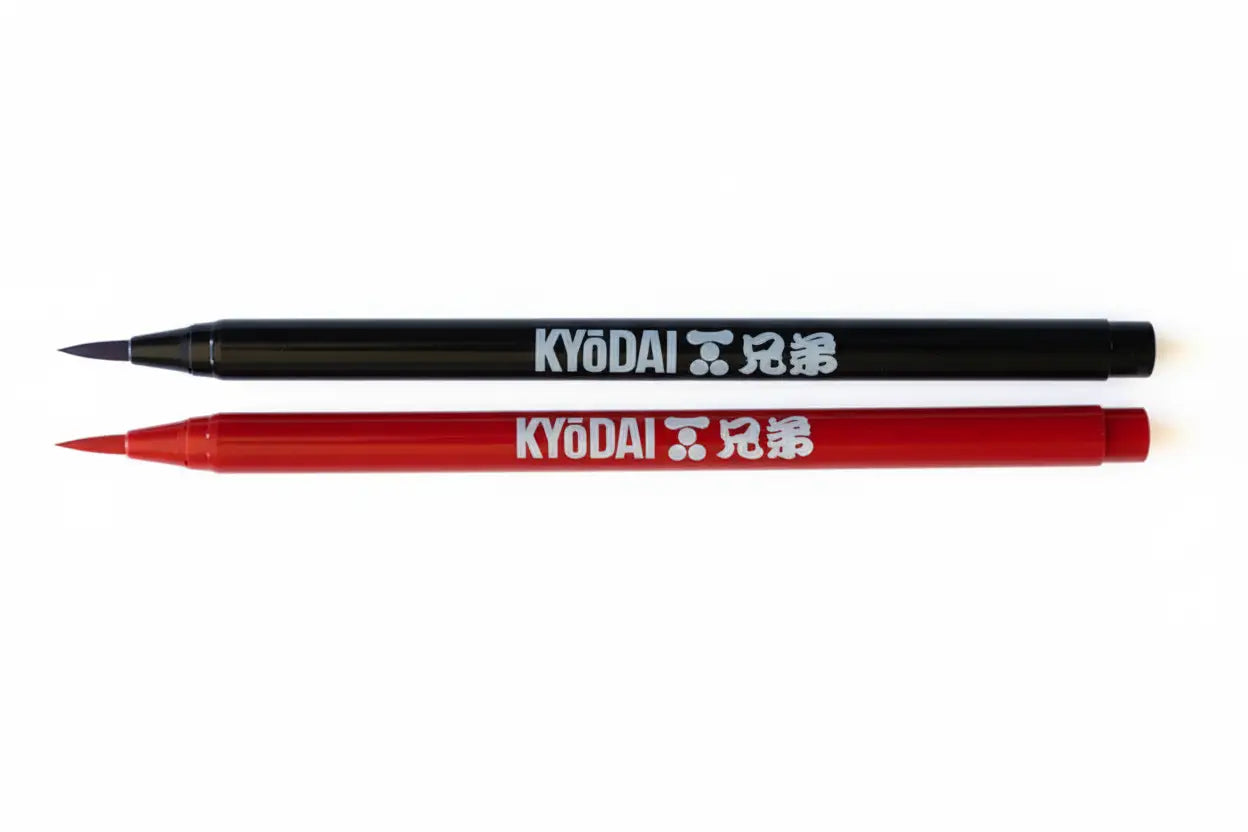 Black and red kyōdai flex-tip brush pens with white branding for precise lettering and illustration use
