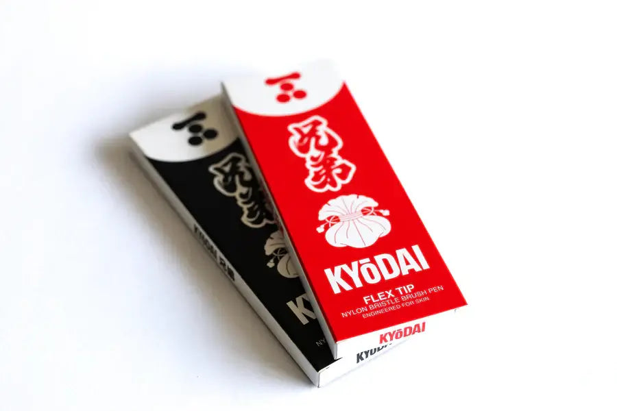 Red and white kyōdai flex-tip brush pen with nylon bristles in branded packaging for precise artistic use