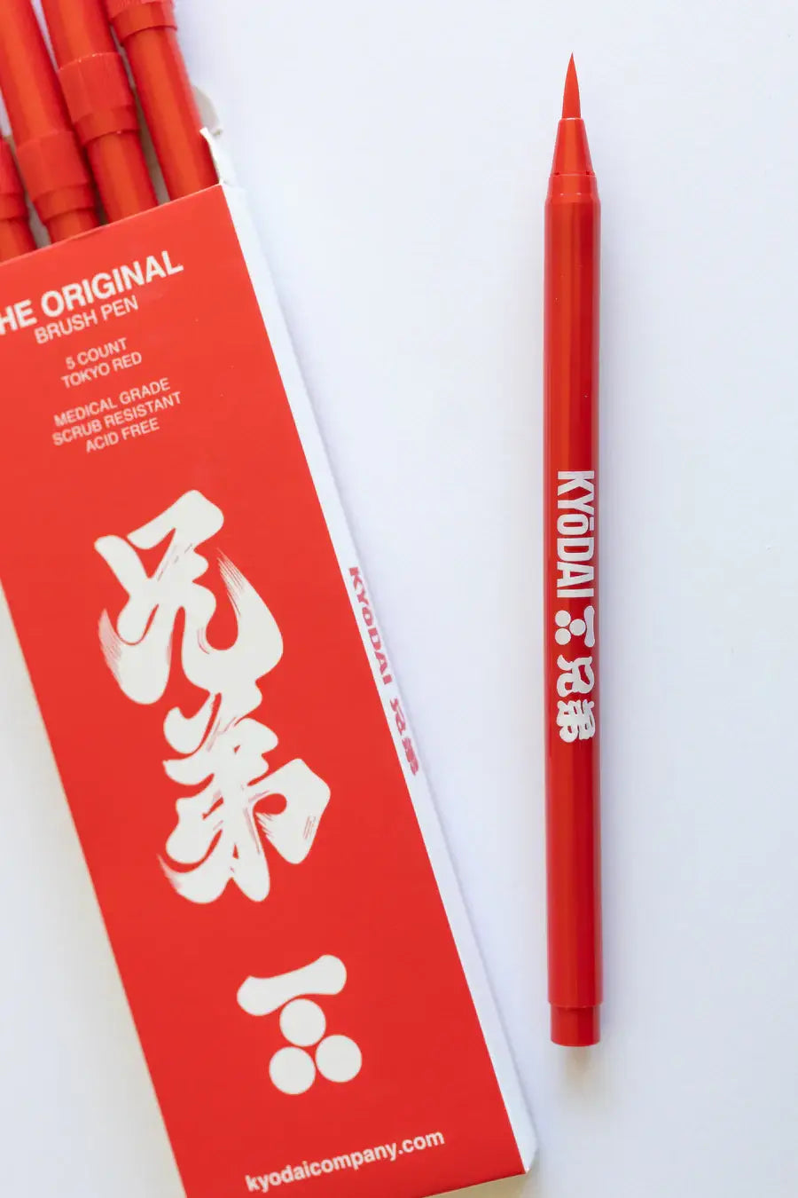A vibrant red kyodai flex tip brush pen with a fine pointed tip and white branding for precise writing