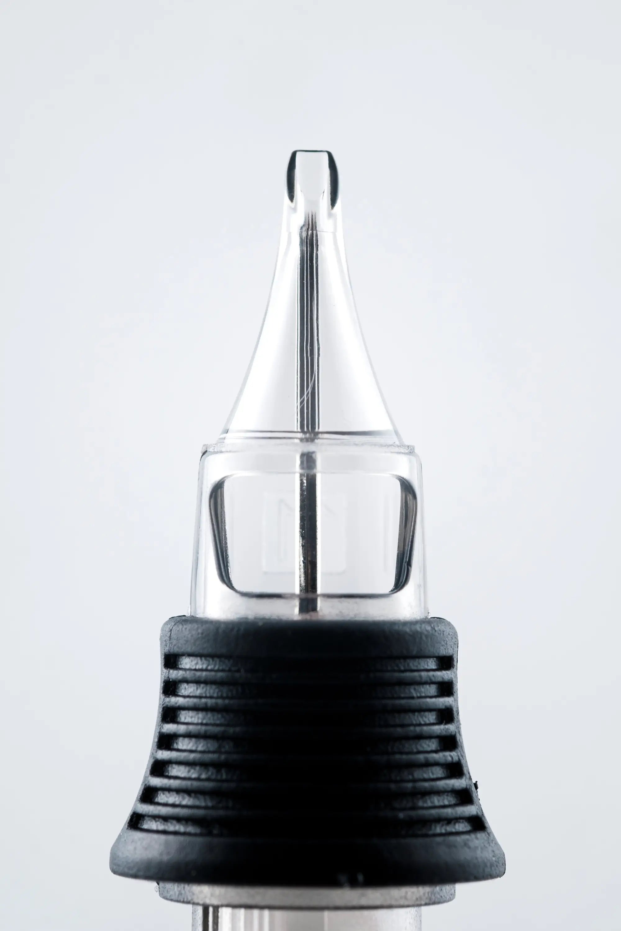 NEXUS round shader cartridge with clear glass needle tip and black textured grip for precision tattooing