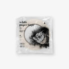 A roll of white paper tape in clear plastic packaging with a black-and-white PIRANHA fish illustration on the label