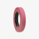 A roll of pink paper painter’s tape with a black core featuring the PIRANHA brand name printed repeatedly