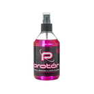 A vibrant pink liquid fills a clear plastic spray bottle with black nozzle labeled proton stencil remover and skin cleanser