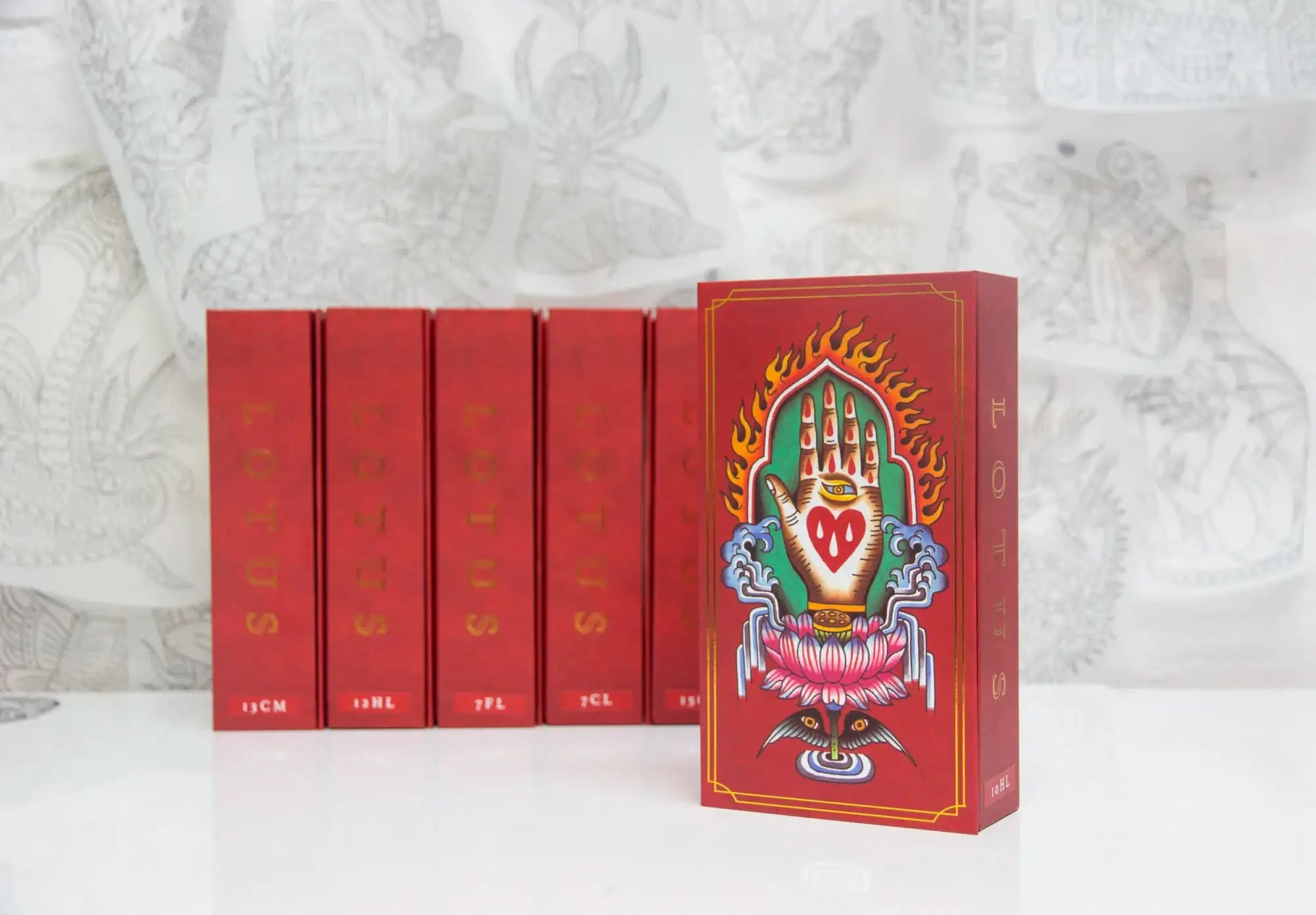 Red rectangular box featuring a vibrant illustration of a hand with a heart inside, surrounded by flames and floral motifs.
