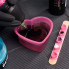 Pink heart shaped silicone SAFERLY rinse cup filled with dark red liquid 150ml capacity for safe rinsing use