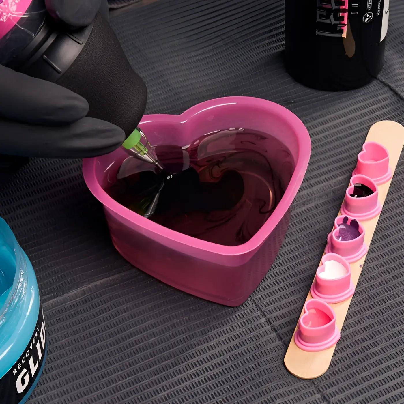 Pink heart shaped silicone SAFERLY rinse cup filled with dark red liquid 150ml capacity for safe rinsing use