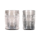 Two translucent silver glass candle holders with embossed geometric patterns.