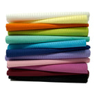 A stack of colorful textured fabric rolls from white to black for unigloves disposable hygienic mats 50pcs