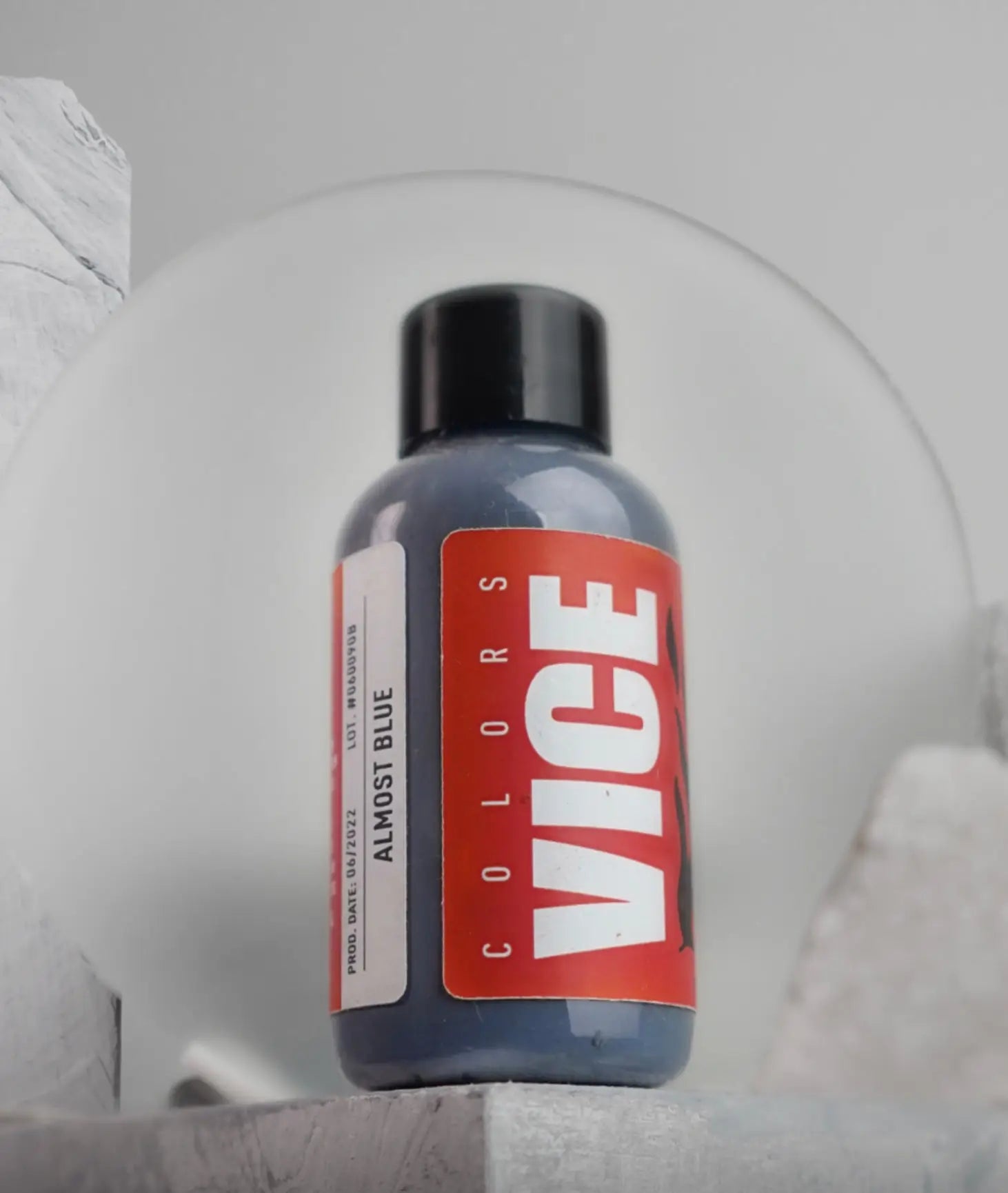 A sleek dark gray bottle of Vice Colors Almost Blue ink with a bold red label and black cap for writing